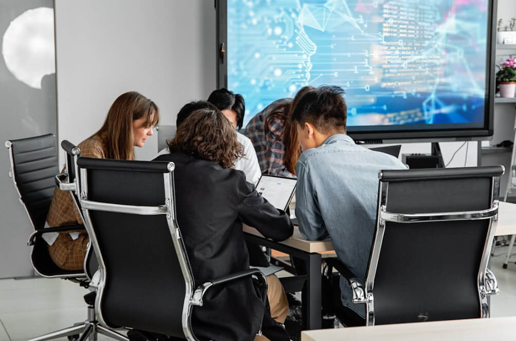 People sitting at table sharing ideas in front of corporate website